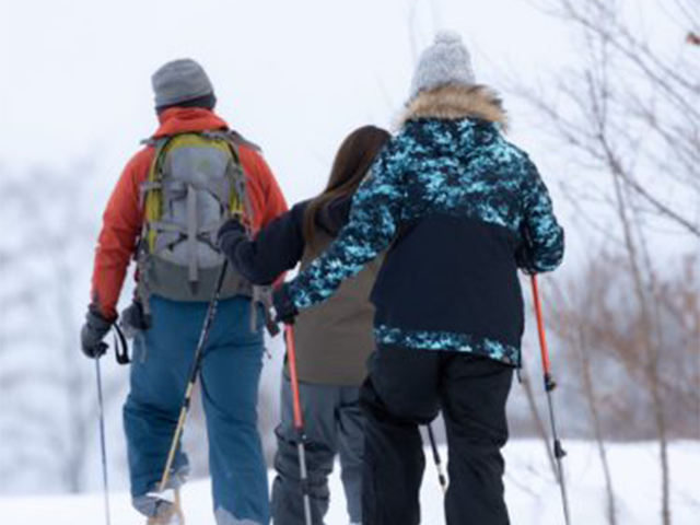 スノーシューで歩く人の写真